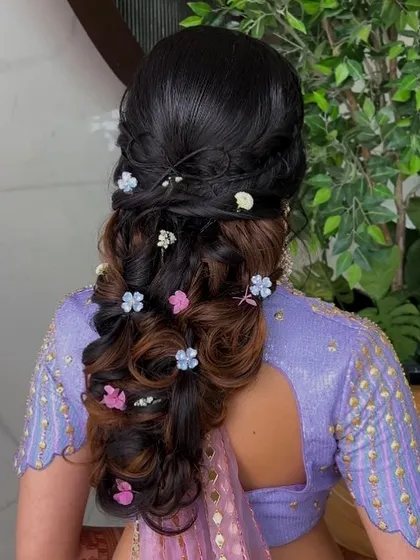 A close-up of the whimsical bubble braid, showing the highlights in the hair and the colorful floral accessories.