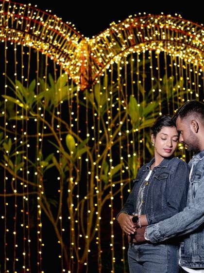 An intimate portrait in front of the large, illuminated heart prop, perfect for capturing a couple's connection.