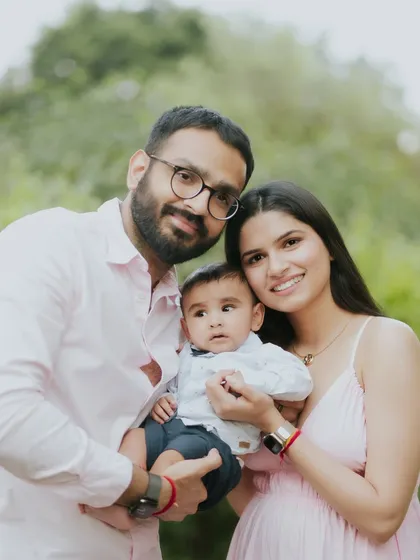 A classic family portrait that radiates warmth and love. The natural green background makes the family stand out.