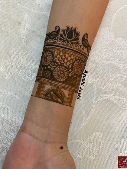 A startup view of the arm band, showing the initial outline and fill work of the birds and lotus design.