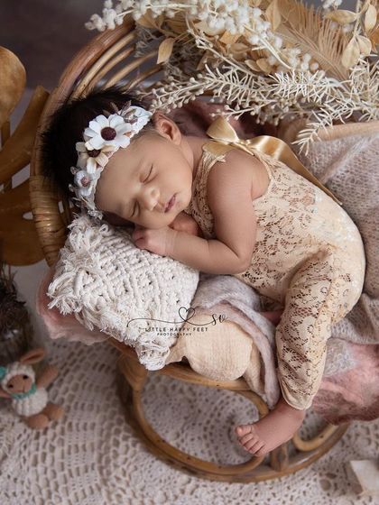 A boho dreamer. The lace romper, macrame pillow, and dried foliage create a beautiful, textured, and stylish portrait with a warm, neutral palette.
