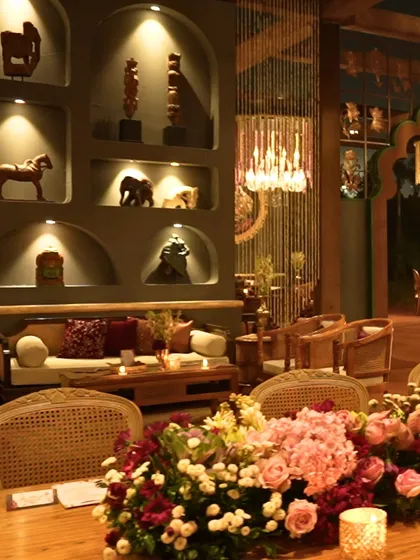 An intimate seating area within a grandly decorated event space. The combination of traditional art pieces and modern lighting showcases our attention to creating a layered and sophisticated atmosphere.