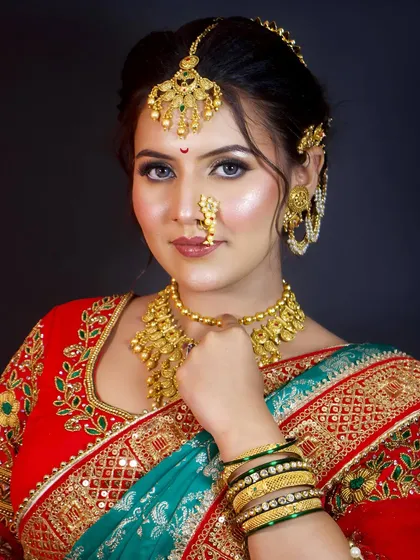 A close-up of a stunning Maharashtrian bride. The look is completed with a traditional matha patti, a classic nath, and soft, glowing makeup.