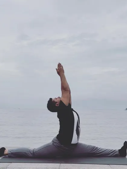 Hanumanasana, the full split, practiced by the sea. This pose embodies devotion and a leap of faith.