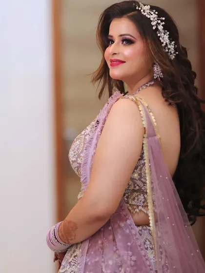 A beautiful engagement bride in a lavender lehenga. The makeup features pink and purple tones to match her outfit, with a lovely hair accessory.