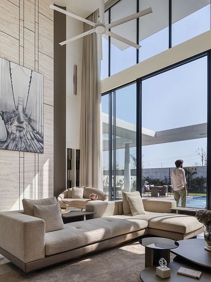 With its double-height ceiling and floor-to-ceiling windows, this living room feels boundless. The space opens directly to the pool and garden, allowing for abundant natural light and panoramic views that create an atmosphere of pure bliss.
