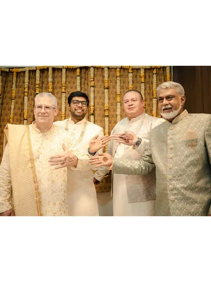 The men from both families, Indian and American, showing off their mehendi designs. A great moment of cultural exchange.
