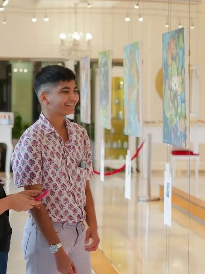 Young visitors enjoying the beautiful floral and landscape paintings at the Impressionism exhibition.