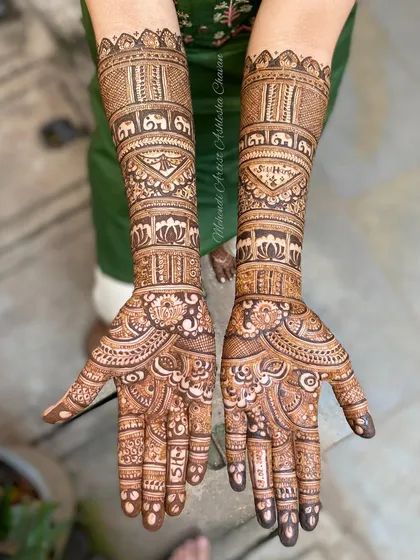 A full bridal mehendi design with personalized initials. The intricate patterns include elephants and lotus flowers, creating a beautiful and meaningful piece of art.