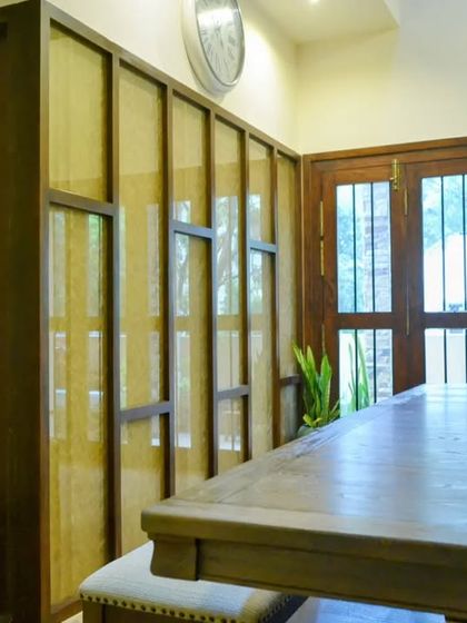 A closer look at the dining table and the textured partition, which allows light to filter through while adding an artistic element to the room.
