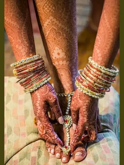 Another beautiful shot of a bride's hands and feet, showcasing the complete bridal look with henna and traditional bangles and anklets.