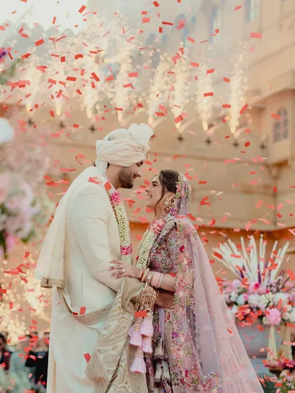 A moment of pure joy as the couple is showered with petals. The grandeur of the Suryagarh palace provides a timeless backdrop to this vibrant and emotional wedding ceremony.