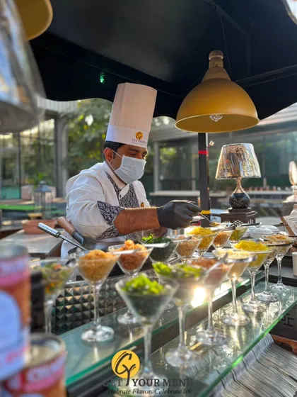 A chef meticulously prepares customized soup servings in martini glasses at our elegant Ouve Soup Counter.