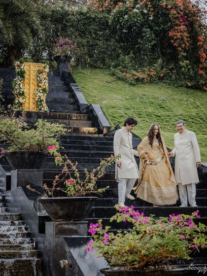 The bride being escorted by her brother and father down the steps, a beautiful family moment.