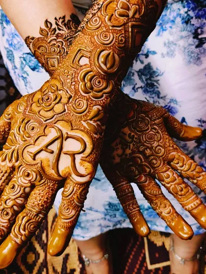 Asbah's mehndi, featuring her and her partner's initials 'AR' and the groom's name 'Aarif' hidden in the design.