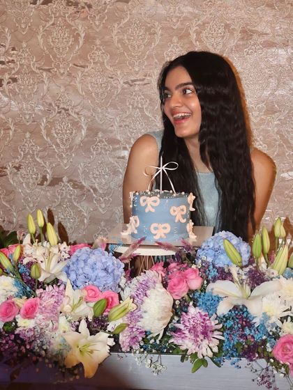 A joyful shot of our founder with her birthday cake, surrounded by a stunning floral arrangement. Thank you for helping us celebrate.