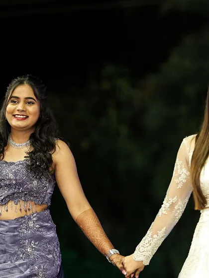 Holding hands with the bride, offering support and sharing a smile before her performance. I'm there to be a friend and a guide on her big day.