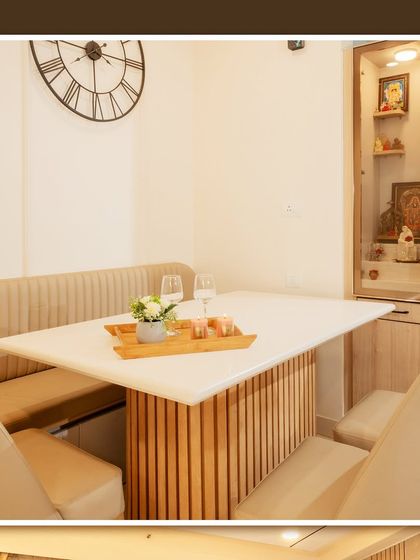 A compact pooja unit integrated next to a dining nook with bench seating, showing how we can incorporate sacred spaces even in smaller apartments.