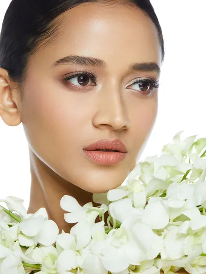 A fresh and clean bridal look with soft, minimal makeup and a beautiful garland of white flowers.