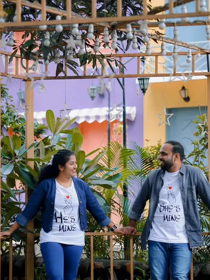 A sweet moment in a colorful gazebo. The couple's matching t-shirts add a personal and fun touch to their pre-wedding photos.