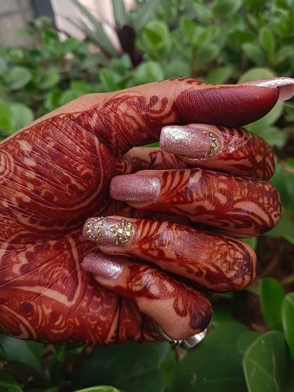 These engagement nails are all about the sparkle. The client chose a pink glitter base with a cluster of gold stones at the cuticle for a look that is both festive and elegant.