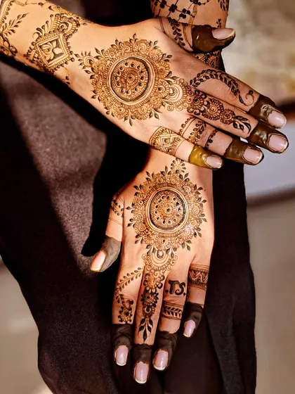 The sunlight beautifully captures the fresh henna paste of this mandala-style engagement mehendi.