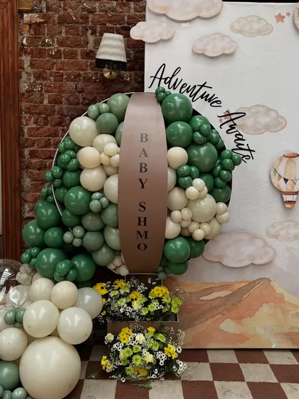 A detailed view of the circular balloon installation with the 'Baby Shmo' signage, combining different shades and sizes of balloons for a textured look.