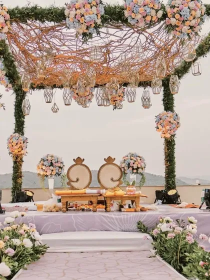 A unique mandap design featuring a canopy of intertwined branches and pastel floral bunches. This rustic-chic style is perfect for a whimsical, enchanted forest theme.