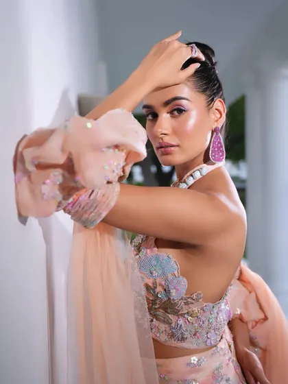 A side profile of the peach gown, showcasing the beautiful details on the sleeves. The styling is modern and fashion-forward.