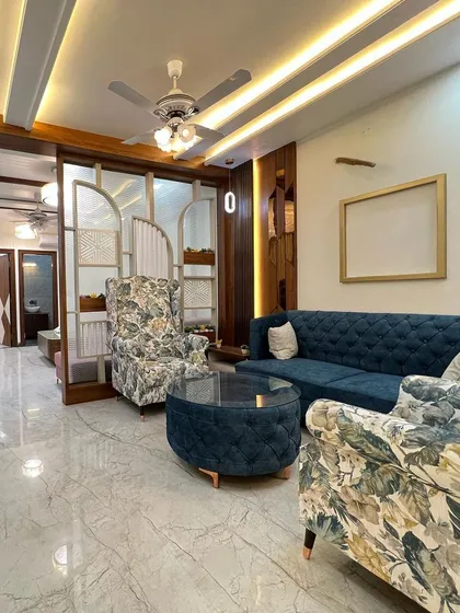 I love mixing patterns and textures. Here, the floral print on the wingback chairs adds a classic touch to a modern living room setup, creating a comfortable and stylish conversation area.