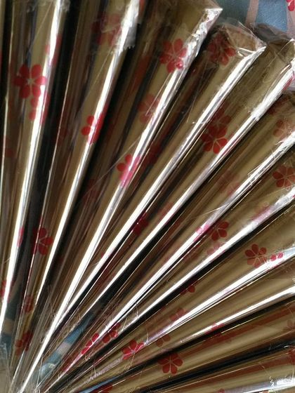 A fan of my henna cones with a delicate red floral pattern on the wrapper. These were prepared for a special bridal order.