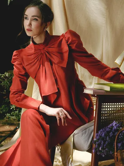 A dramatic and romantic evening look. The bold red dress is paired with a sophisticated makeup look, featuring a soft smokey eye and a defined lip, creating a sense of timeless glamour.