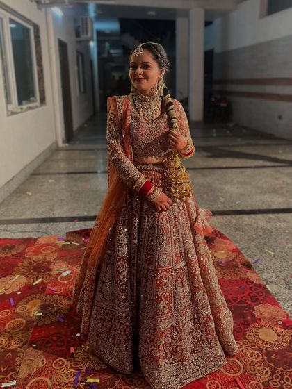 A beautiful bride ready for her big day in a classic red and gold embroidered lehenga. The full-sleeve blouse and heavy jewellery complete this timeless bridal look.