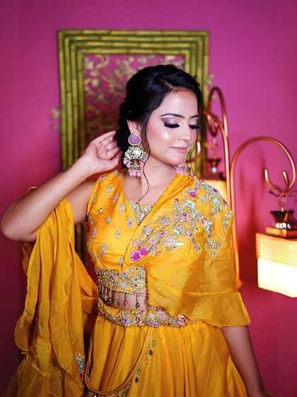 A close-up of the yellow Haldi lehenga, highlighting the intricate embroidery on the blouse and the beautiful earrings.