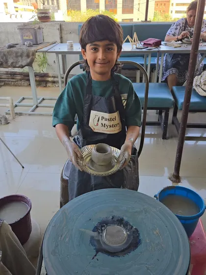 Look at that proud face. This young artist has just finished shaping his first pot on the wheel. My goal is for every child to leave with a sense of accomplishment and a masterpiece they're excited to show off.