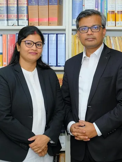 A professional portrait with my colleague against the backdrop of our firm's law library, the foundation of our legal research and arguments.