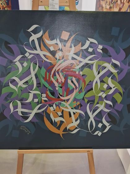 A beautiful calligraphy piece on an easel, blending traditional script with contemporary colors.