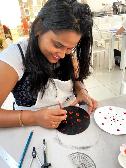 A participant works on her dot mandala, fully absorbed in the meditative process of creating the intricate design.