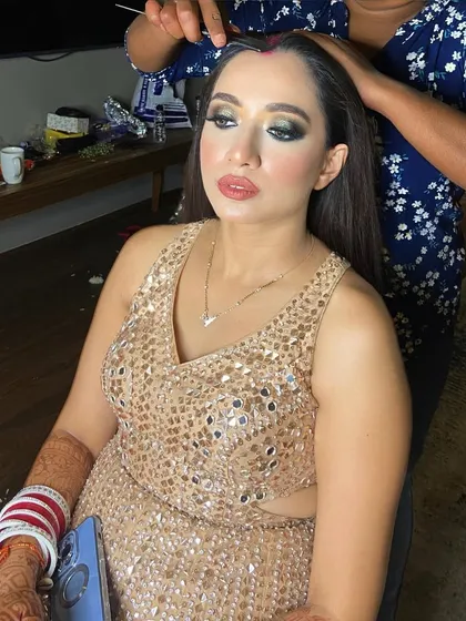 In the making of this bold reception look. You can see the application of a dark, smokey eye, which creates a powerful and confident style for the evening.