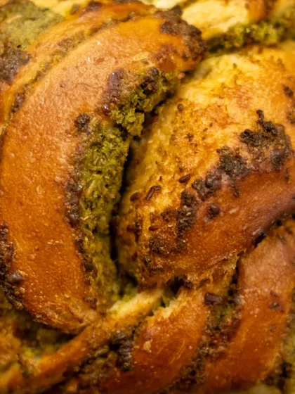 A close-up texture shot of our Chilli Cheese Toast Babka, showing the beautiful swirls of pesto and golden-brown crust.