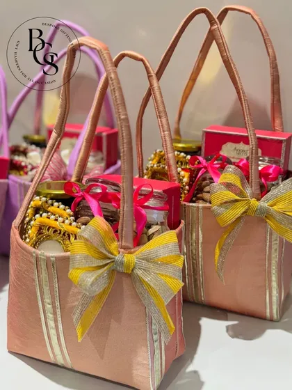 These elegant fabric gift bags in pastel pink are filled with treats for Diwali. This is a great alternative to traditional boxes or baskets, offering a soft and luxurious feel.