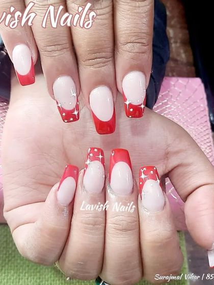 A fun red French manicure with white polka dots on the tips.