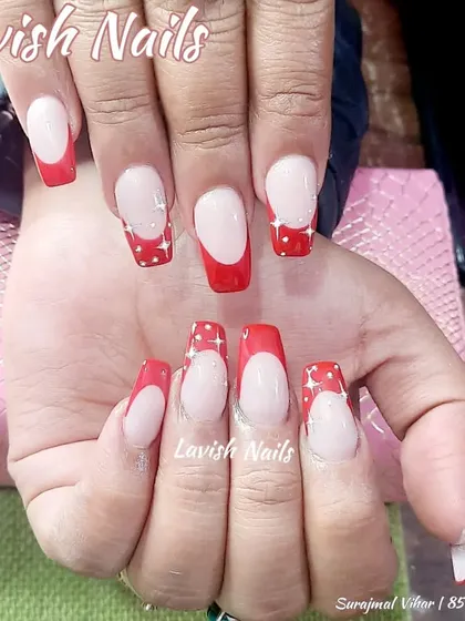 A fun red French manicure with white polka dots on the tips.