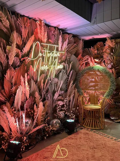 I love creating stylish photo opportunities for your guests. This corner from a Diwali party features a custom neon sign, a chic peacock chair, and a backdrop of pampas grass, blending modern trends with a festive feel.