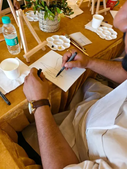 The creative process in action. A guest at one of our parties carefully sketches out his design before painting. We encourage everyone to follow our guidance or add their own personal flair to their artwork.