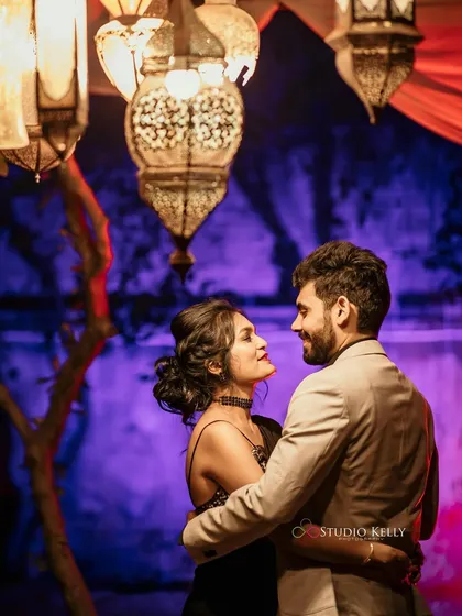 A romantic evening shot under Moroccan-style lanterns. The makeup is glamorous and defined to stand out in the dramatic, colorful lighting.