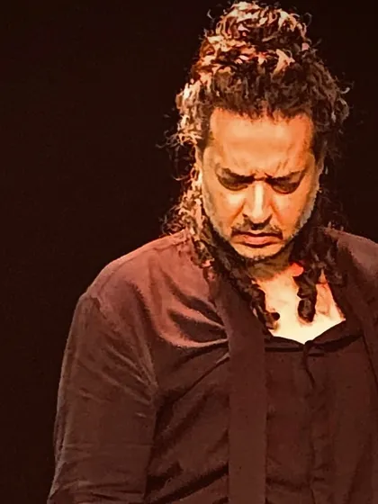 A close-up, intense portrait from an intimate black box performance.