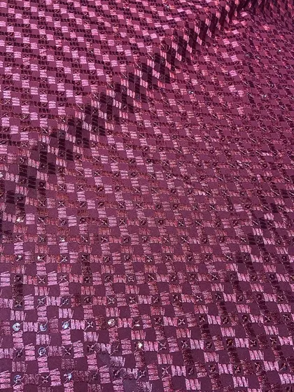 A unique maroon Chikankari fabric with a checkerboard-style embroidery pattern and sequins. This textile can be used to create a truly distinctive custom kurta.