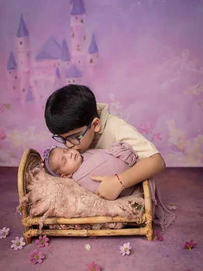 A tender kiss for his new sister, who is resting in a tiny, rustic bed fit for a princess.