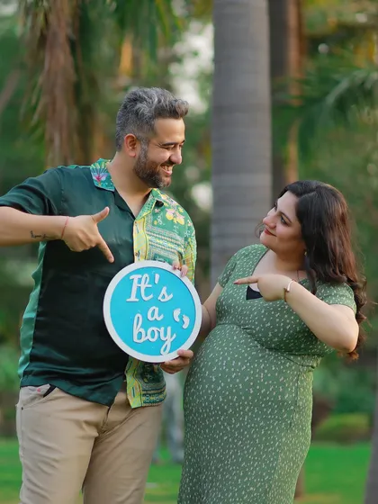 A fun gender reveal moment captured outdoors. The couple's joyful expressions and the "It's a boy" sign make this a happy and memorable shot.